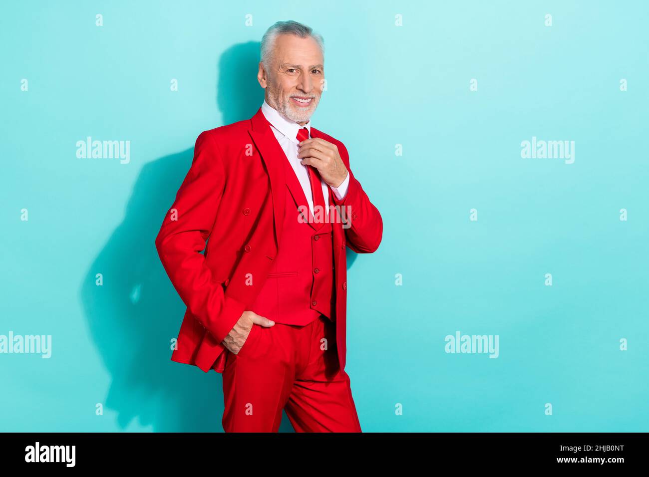 Photo de joli retraité homme porter rouge trois pièces costume lien de bras vide espace isolé turquoise couleur fond Banque D'Images
