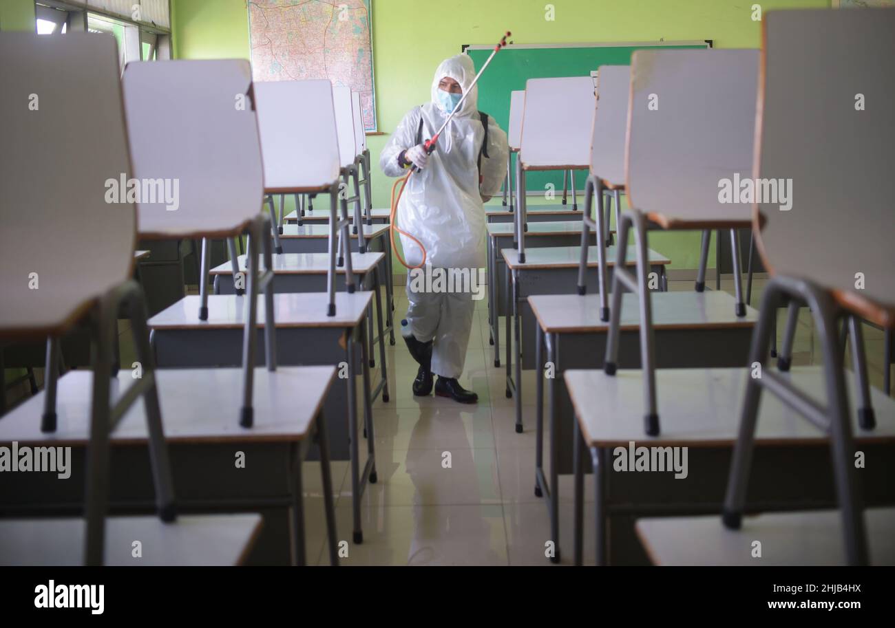 Jakarta, Indonésie.28th janvier 2022.Un membre de la Société indonésienne de la Croix-Rouge procède à la désinfection dans un bâtiment scolaire de Jakarta, en Indonésie, le 28 janvier 2022.L'Indonésie a confirmé jeudi 8 077 nouveaux cas de COVID-19, soit la plus forte augmentation d'un jour depuis le 2 septembre 2021, dans le contexte de la propagation de la variante Omicron dans le pays.Credit: Zulkarnain/Xinhua/Alamy Live News Banque D'Images