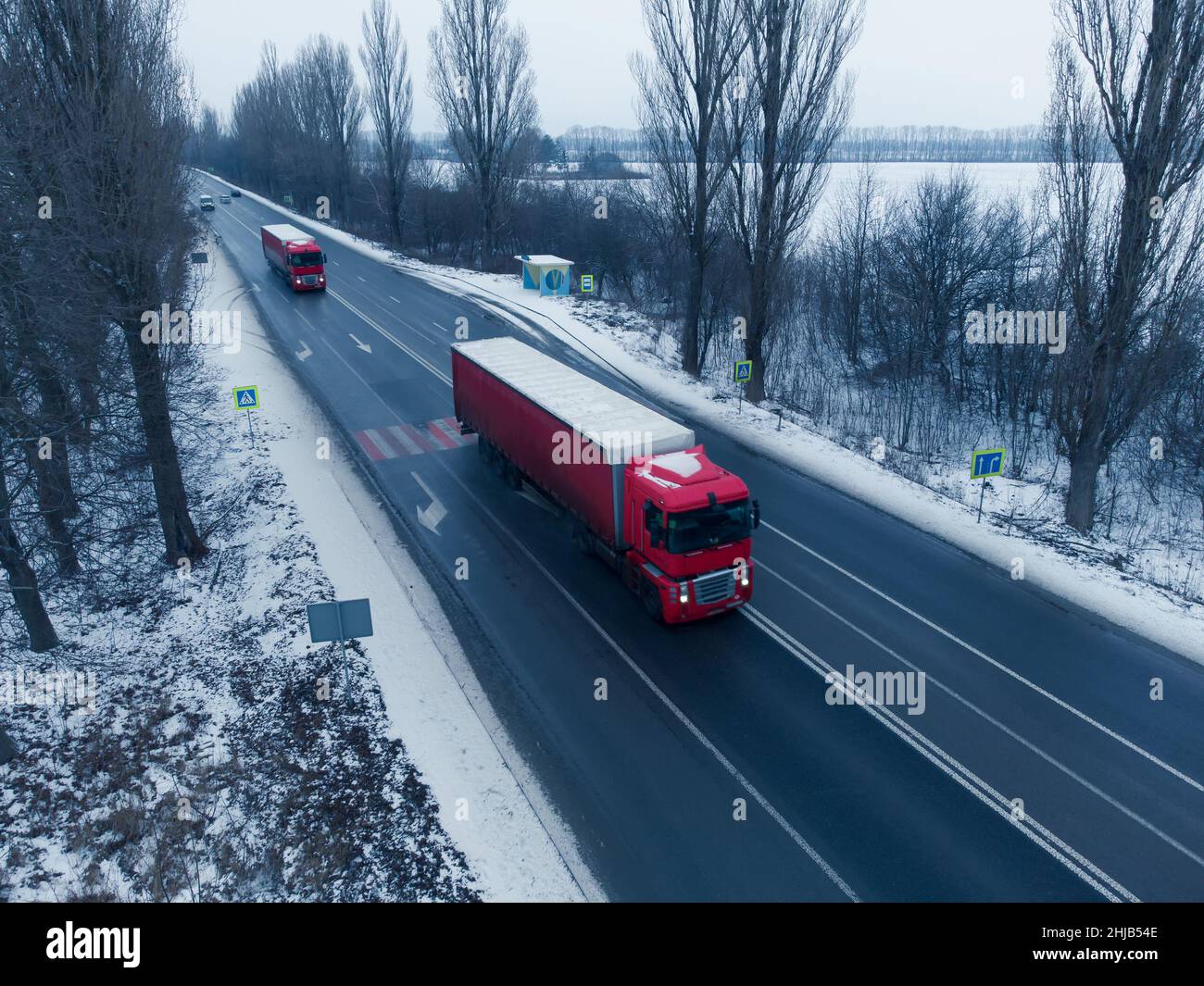 Deux camions rouges sur la route en hiver.Logistique et fret Banque D'Images