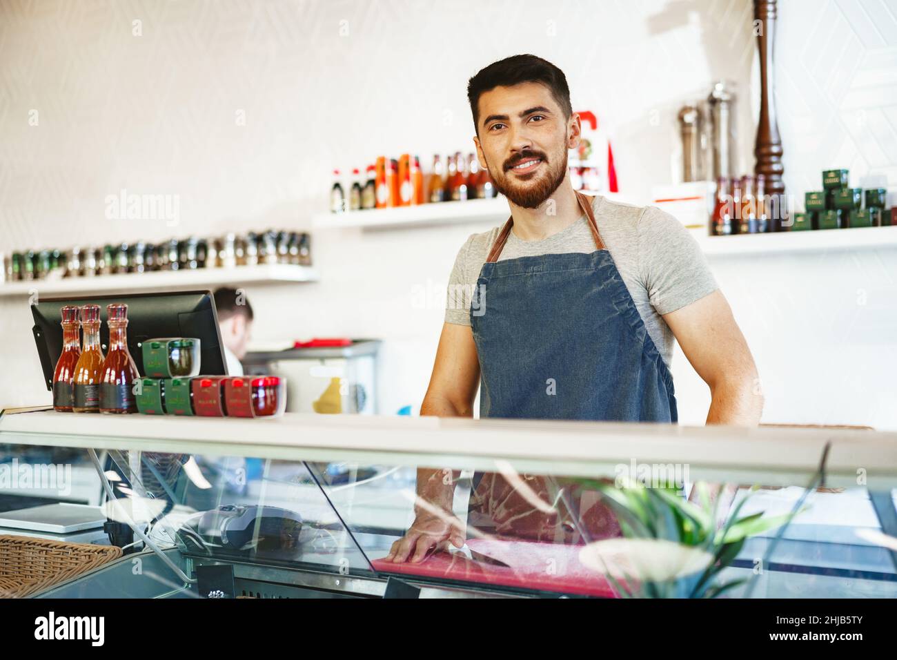Portrait d'un jeune vendeur confiant dans la boutique du boucher Banque D'Images