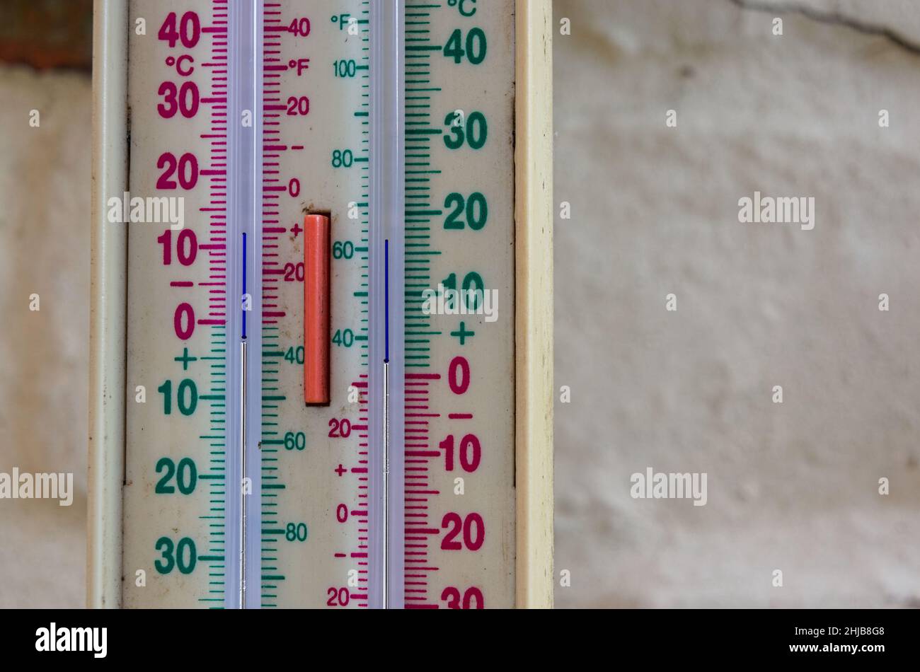 Thermomètre minimum de style ancien sur un mur de cour affichant une température inférieure à la température de congélation Banque D'Images
