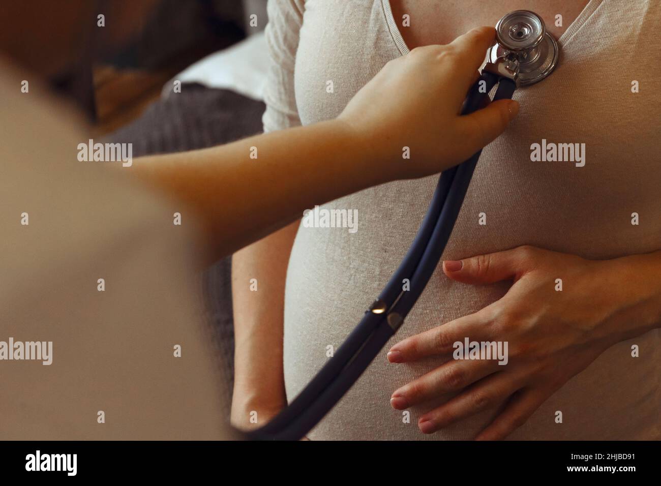 Médecin écoutant le rythme cardiaque de la femme enceinte avec stéthoscope lors d'un rendez-vous de soins prénatals à l'hôpital, dose de culture.Maladie cardiaque pendant la grossesse Banque D'Images