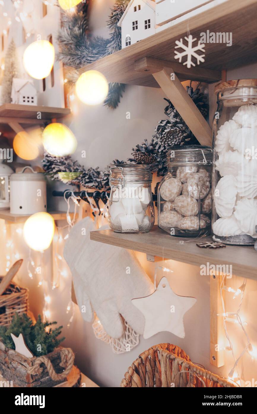 Photo de Noël de la boutique de bonbons décorée dans le style des fêtes du nouvel an, des rangées de pots en verre avec différents cookies, guimauve et pain d'épice, lumineux Banque D'Images