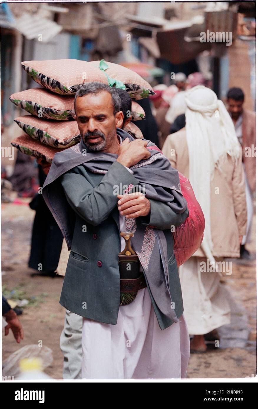 Homme tribal transportant des marchandises à Sana'a, la plus grande ville et capitale du Yémen, pays du Moyen-Orient Banque D'Images