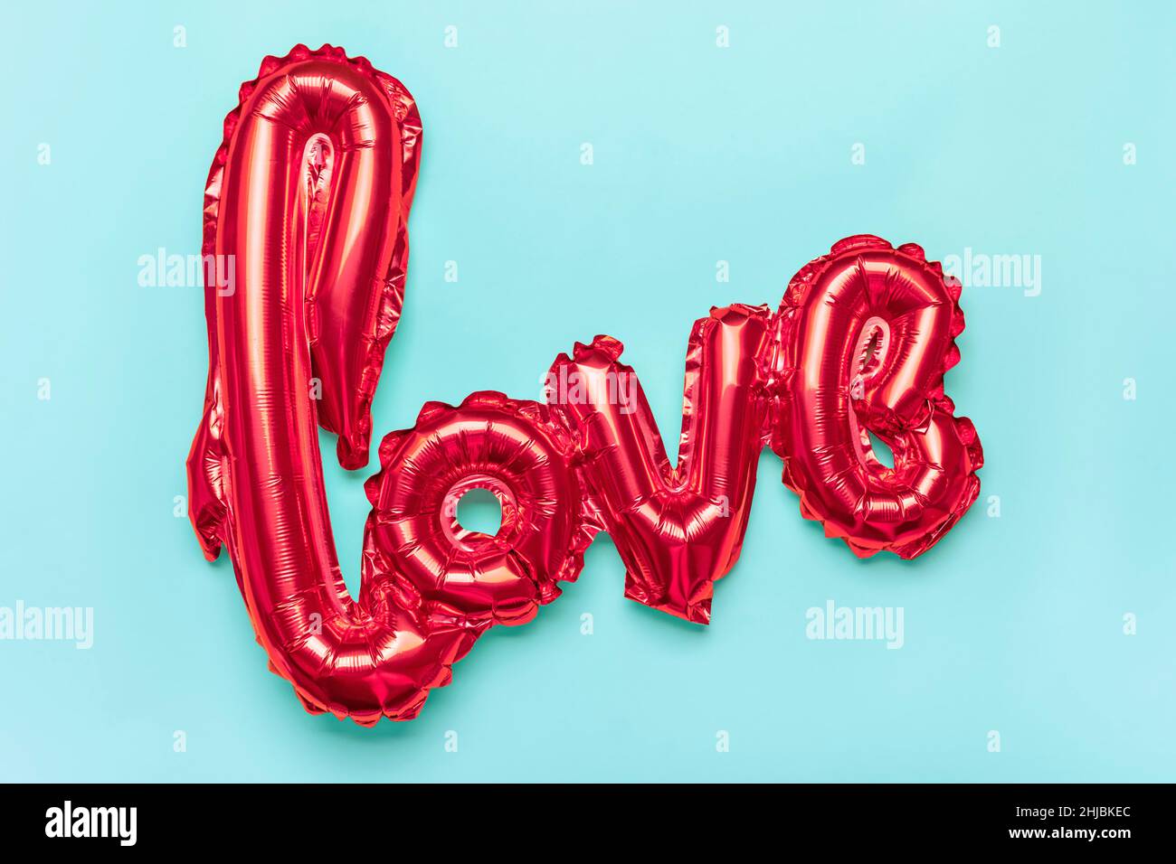 Lettres gonflables amour dans la couleur rouge isolé sur fond bleu plat Lay Top View carte de vacances, Happy Valentines Day concept Amour dans l'air Banque D'Images