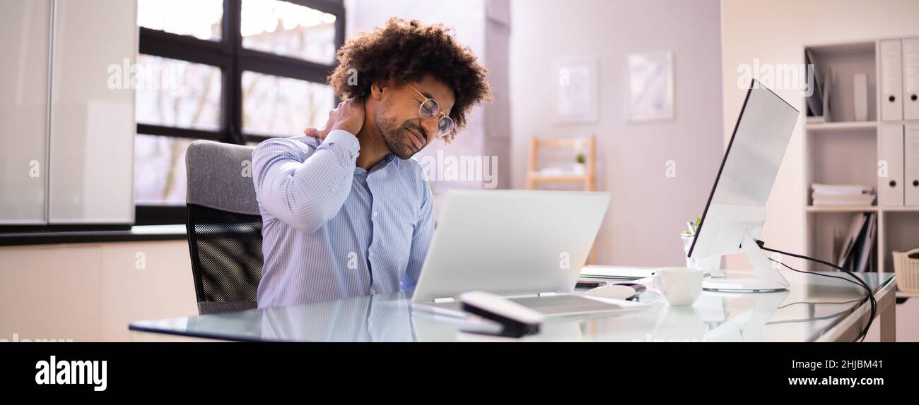 African American Man Back pain au travail de mauvaise posture Banque D'Images
