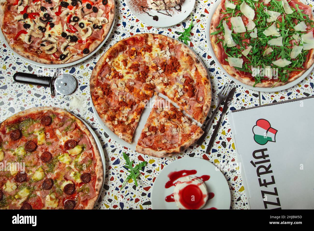 Dîner pizza.Plat de différents types de pizzas et desserts italiens sur la table du restaurant, vue de dessus, large composition. Banque D'Images Dîner pizza.Plat de différents types de pizzas et desserts italiens sur la table du restaurant, vue de dessus, large composition. Banque D'Images