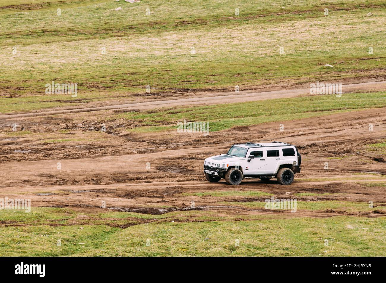 Voiture SUV White Hummer H2 tout terrain dans les montagnes du printemps en Géorgie.Paysage de gorge au printemps Banque D'Images