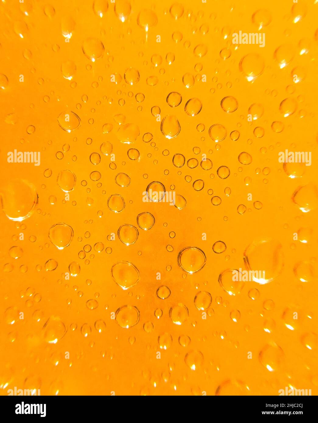 gros plan semi-abstrait de gouttelettes d'eau sur fond orange clair Banque D'Images