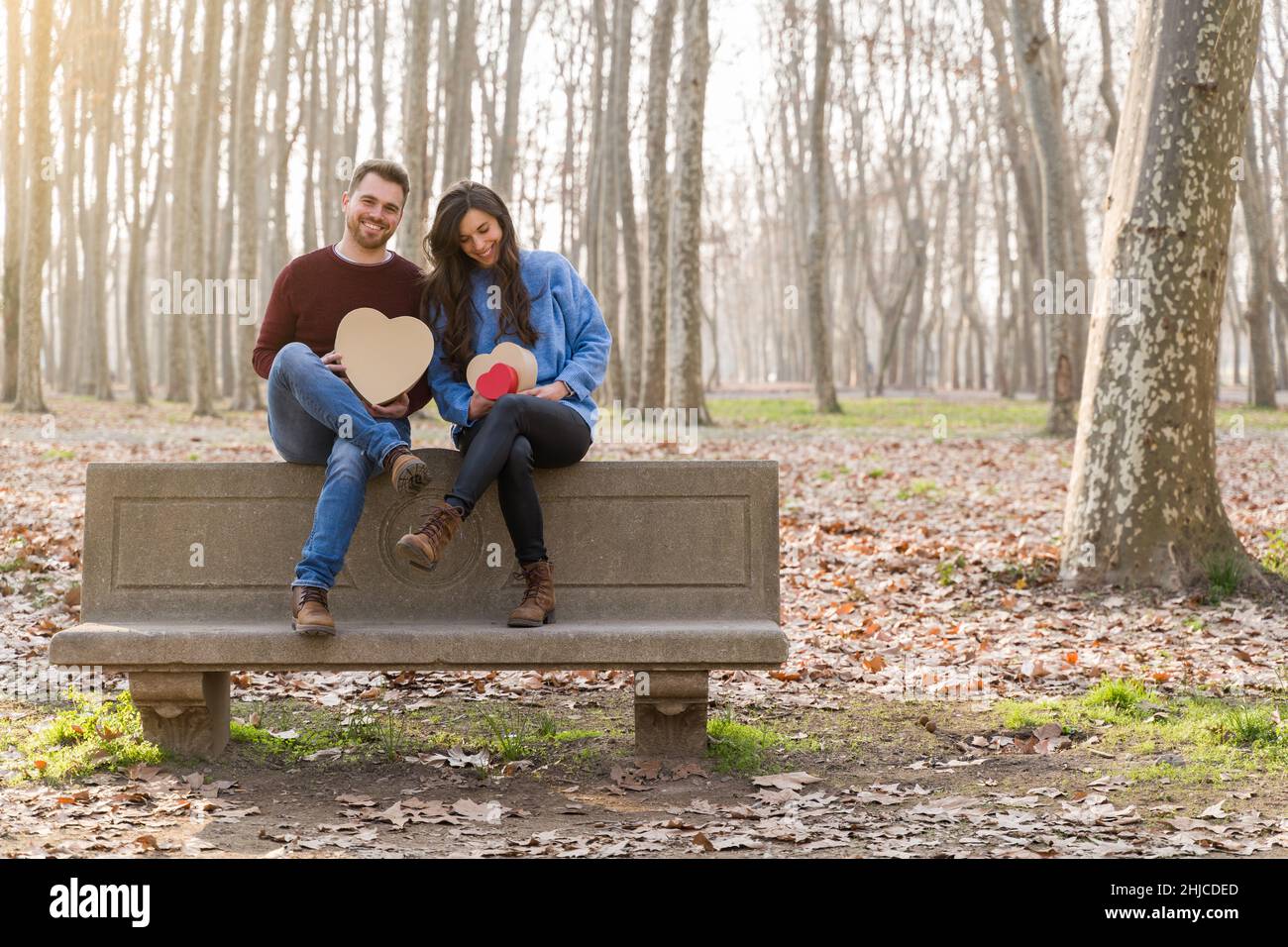 Jeune couple célébrant la Saint-Valentin en faisant un cadeau dans un parc Banque D'Images