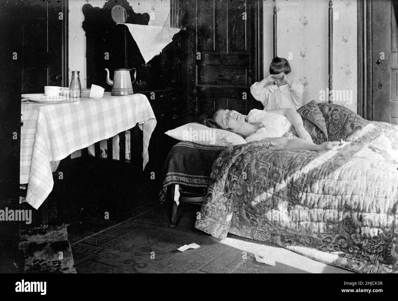 Une femme malade à la maison avec la grippe pendant la pandémie de grippe espagnole, novembre 1918.Légende originale : « sa sœur n'avait pas vu Mme Brown depuis près d'une semaine, et avec M. Brown, soldat en France, elle s'inquiétait tellement de téléphoner au service à domicile de la Croix-Rouge qui est arrivé juste à temps pour sauver Mme Brown des griffes de la grippe. »La grippe espagnole de 1918 à 1920 a été une pandémie de grippe exceptionnellement mortelle causée par le virus de la grippe a H1N1. Banque D'Images