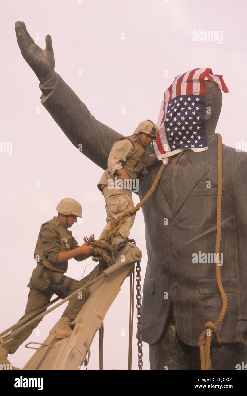 Bagdad, Iraq; 9 avril 2003.LES Marines AMÉRICAINS nouent une chaîne autour du cou d'une statue du dictateur irakien Saddam Hussein alors qu'ils se préparent à la déchirer de son piédestal sur la place Firdos de Bagdad.La statue -- la hauteur d'environ quatre hommes -- était l'un des symboles de la domination de Saddam sur l'Irak. Banque D'Images