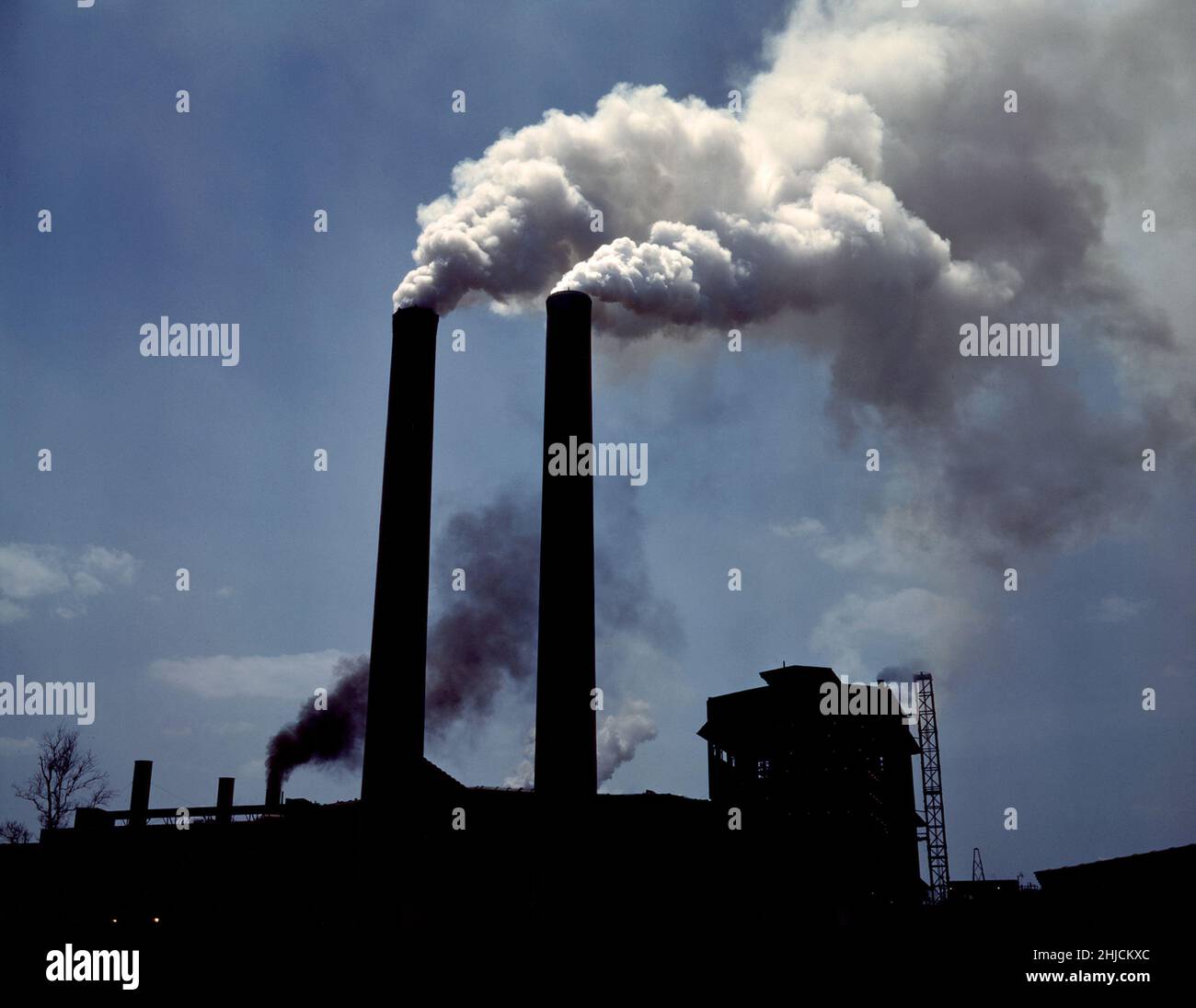 Cheminées d'une usine de production de guerre, Seconde Guerre mondiale, 1942.Photographié par Alfred T. Palmer, plus connu pour ses photographies représentant Americana pendant la Seconde Guerre mondialeIl a été photographe de l'Office of War information de 1942 à 1943. Banque D'Images