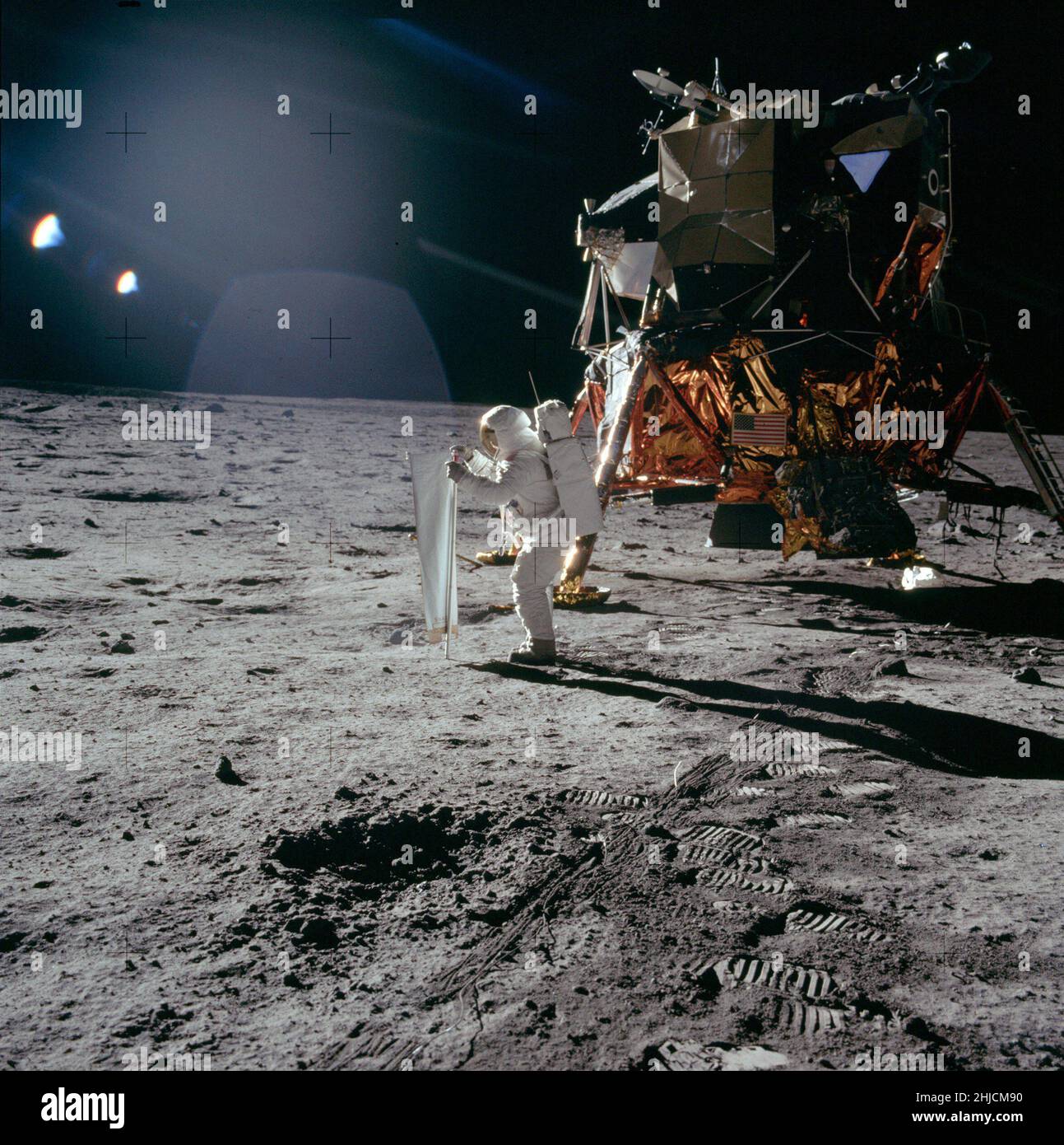 Les astronautes d'Apollo 11 Neil Armstrong et Edwin 'Buzz' Aldrin ont effectué le premier atterrissage lunaire sous surveillance le 20 juillet 1969.Ici Buzz déploie le collecteur de vent solaire, une feuille d'aluminium qu'il pointe vers le Soleil. À la fin de l'EVA, après avoir laissé le SWC exposé au Soleil pendant environ 1 heures et 17 minutes,Buzz enroule la feuille et la remballe dans un sac pour analyse sur Terre.Noter le jeu considérable entre le bas de la cloche du moteur de descente et la surface en dessous. Banque D'Images Les astronautes d'Apollo 11 Neil Armstrong et Edwin 'Buzz' Aldrin ont effectué le premier atterrissage lunaire sous surveillance le 20 juillet 1969.Ici Buzz déploie le collecteur de vent solaire, une feuille d'aluminium qu'il pointe vers le Soleil. À la fin de l'EVA, après avoir laissé le SWC exposé au Soleil pendant environ 1 heures et 17 minutes,Buzz enroule la feuille et la remballe dans un sac pour analyse sur Terre.Noter le jeu considérable entre le bas de la cloche du moteur de descente et la surface en dessous. Banque D'Images