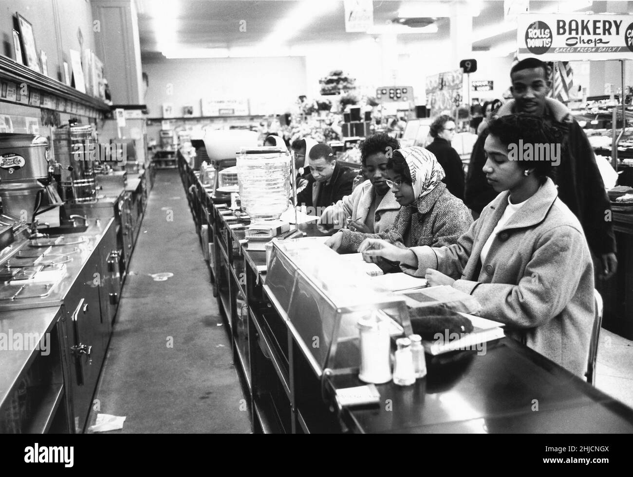 9 février 1960, Charlotte, Caroline du Nord. Les étudiants avaient dit au chef de police ce qu'ils allaient faire à l'avance. Le chef de la police avait promis de ne pas procéder à des arrestations s'ils le faisaient de manière ordonnée et il a gardé sa parole; aucune police n'a jamais comparu devant les sit-ins de Charlotte et il n'y a pas eu d'arrestations. Après quelques heures, les étudiants sont partis et les magasins ont mis des affiches indiquant que leurs comptoirs de repas étaient temporairement fermés. Sur 3 juillet, les comptoirs de Woolworth ont été rouverts à tout le monde. Banque D'Images