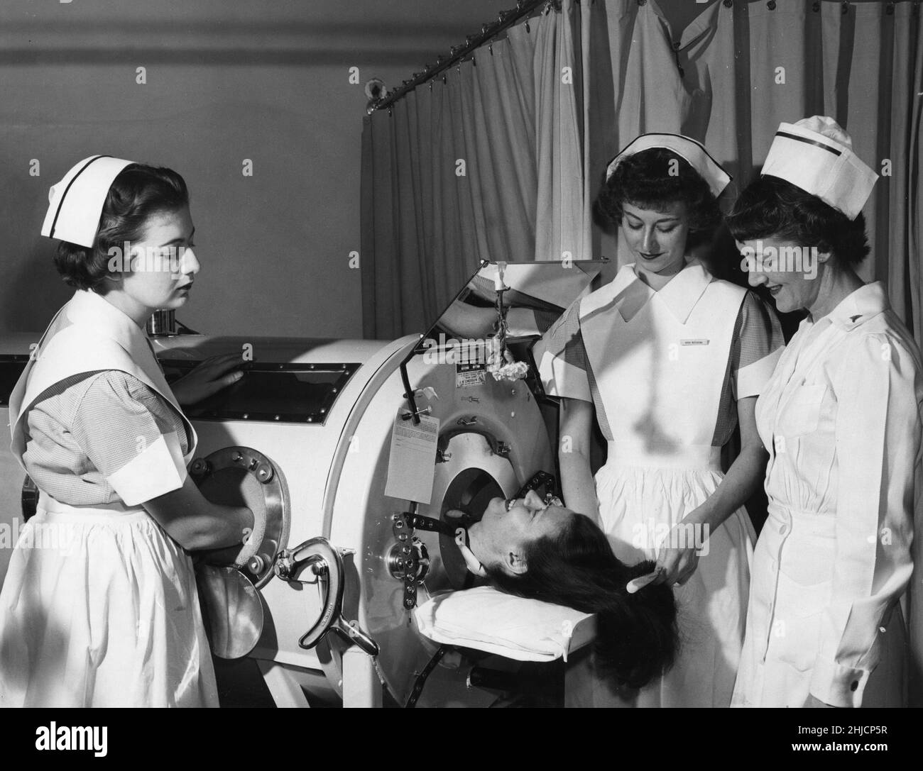 Les infirmières étudiantes reçoivent des instructions sur le fonctionnement d'un poumon de fer, c.1950. Banque D'Images
