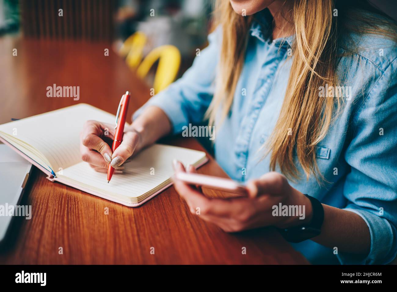 Une étudiante prend des notes dans un carnet Banque D'Images