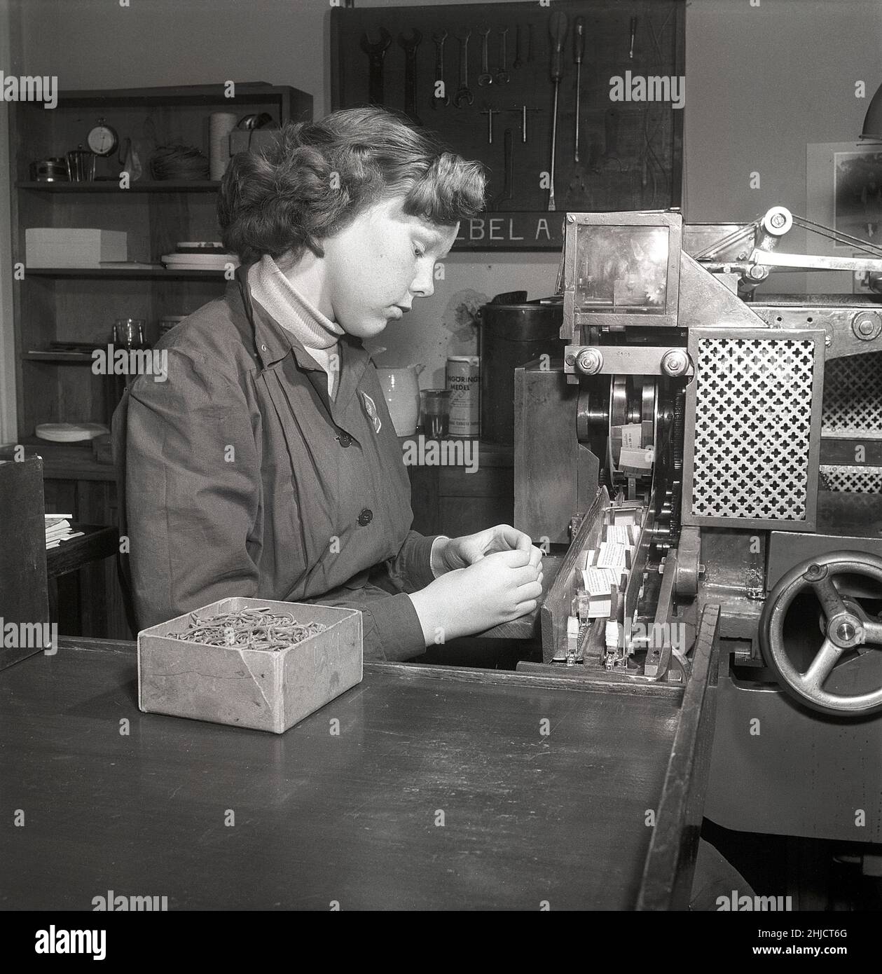 Production de timbres-poste en 1950s.Une jeune femme au timbre suédois printworks du poste suédois à la machine produisant des livrets de timbres.Suède 1951 Kristoffersson réf. bc46-7 Banque D'Images