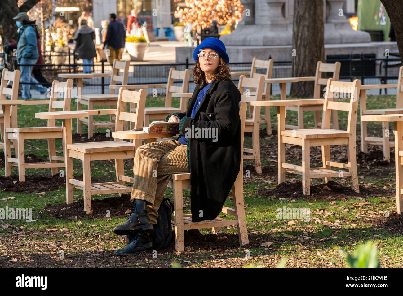 Les gens sont assis dans la version sans branches de “BrierPatch” par l'artiste Hugh Hayden sur une pelouse à Madison Square Park à New York le mercredi 20 janvier 2022.Une centaine de bureaux d'école avec branches d'arbre émergent sont construits dans un modèle de grille référençant un patch de brier, qui est protecteur et dangereux en même temps.L'œuvre d'art publique sera en vue jusqu'au 24 avril 2022.(© Richard B. Levine) Banque D'Images