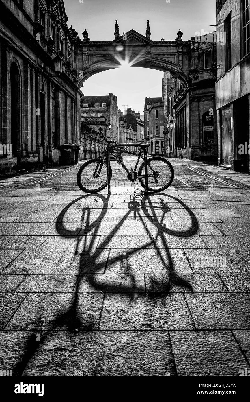 Ombres tôt le matin, vélo sur les rues pavées de Bath Angleterre, image spectaculaire en noir et blanc. Banque D'Images
