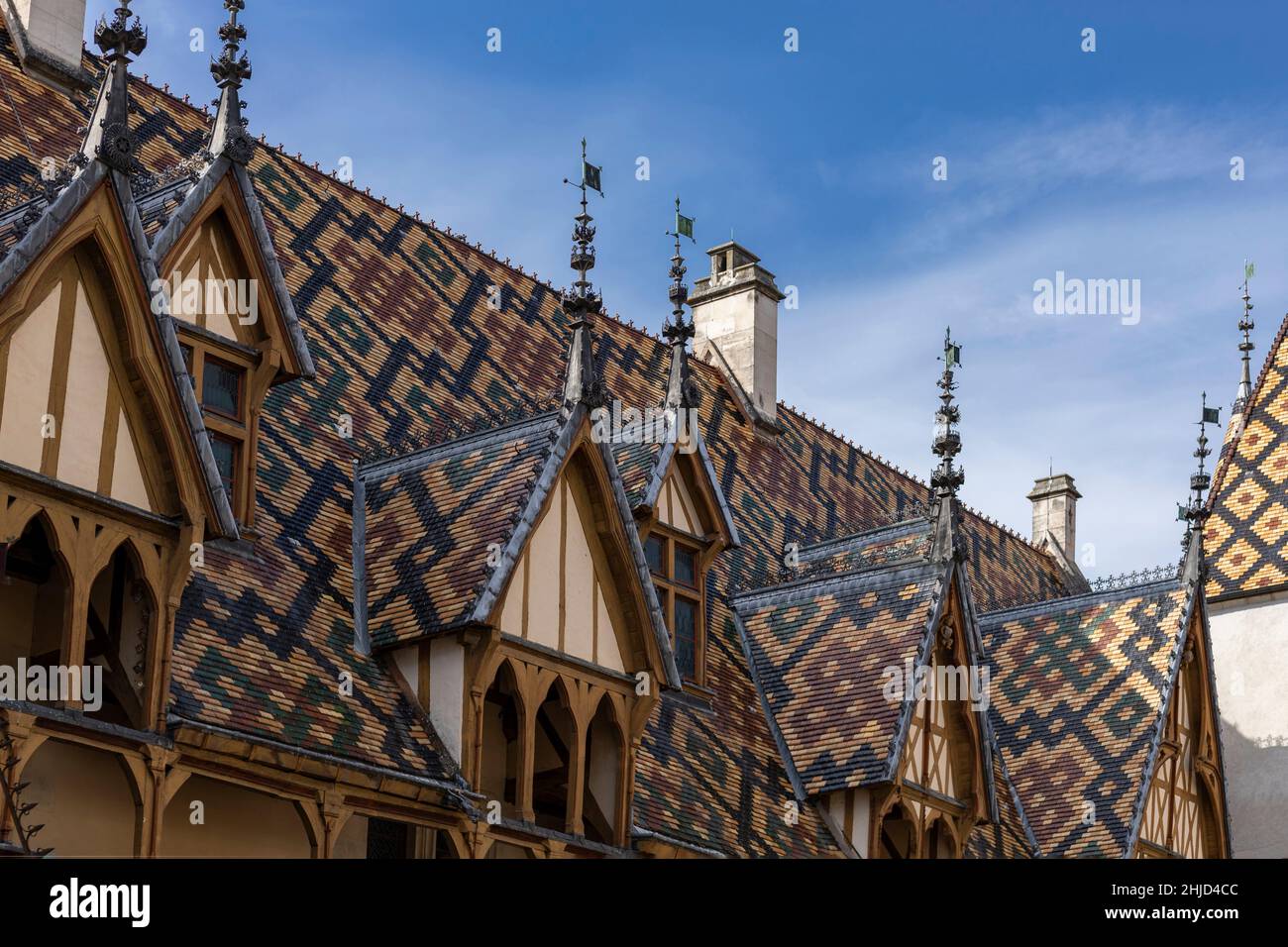 Les rooves carrelées aux couleurs vives uniques de la région Bourgogne de France contre un ciel bleu Banque D'Images