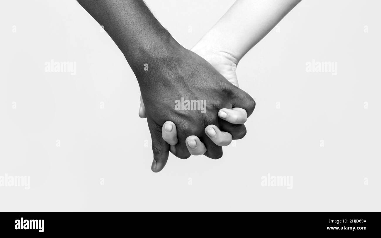 Partenariat d'amour de main noir et blanc. Noir, blanc femme et homme tenant les mains ensemble. Femme blanche, homme africain tenant la main symbole de l'amitié Banque D'Images