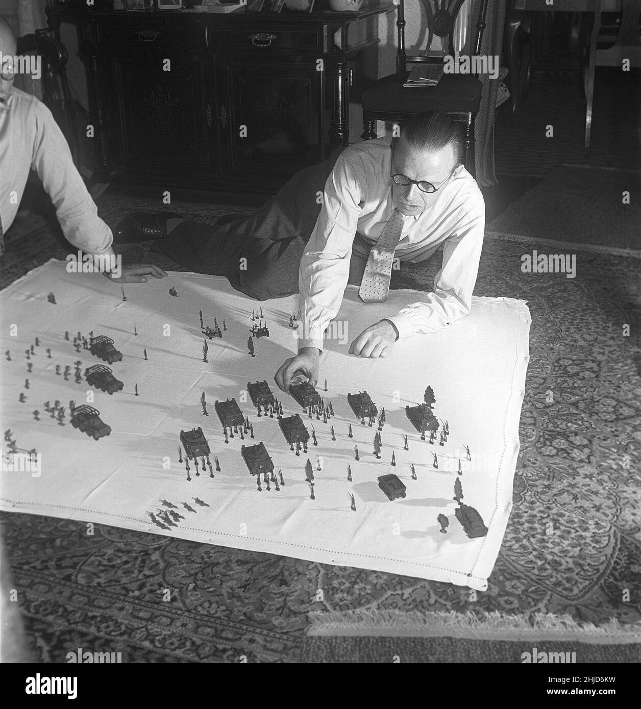 Soldats de l'étain dans les 1950s.Un membre des collectionneurs danois d'étain avec sa collection de soldats et de jouets en étain sous forme de chars d'armée disposés comme sur un champ de bataille.Les soldats de l'étain étaient un passe-temps historique souvent dans les thèmes.L'étain a été fondu et versé sous forme de figures qui, lorsqu'ils avaient refroidi et pris hors des formes ont été peintes avec soin.1952. Kristoffersson réf. BE30-6 Banque D'Images