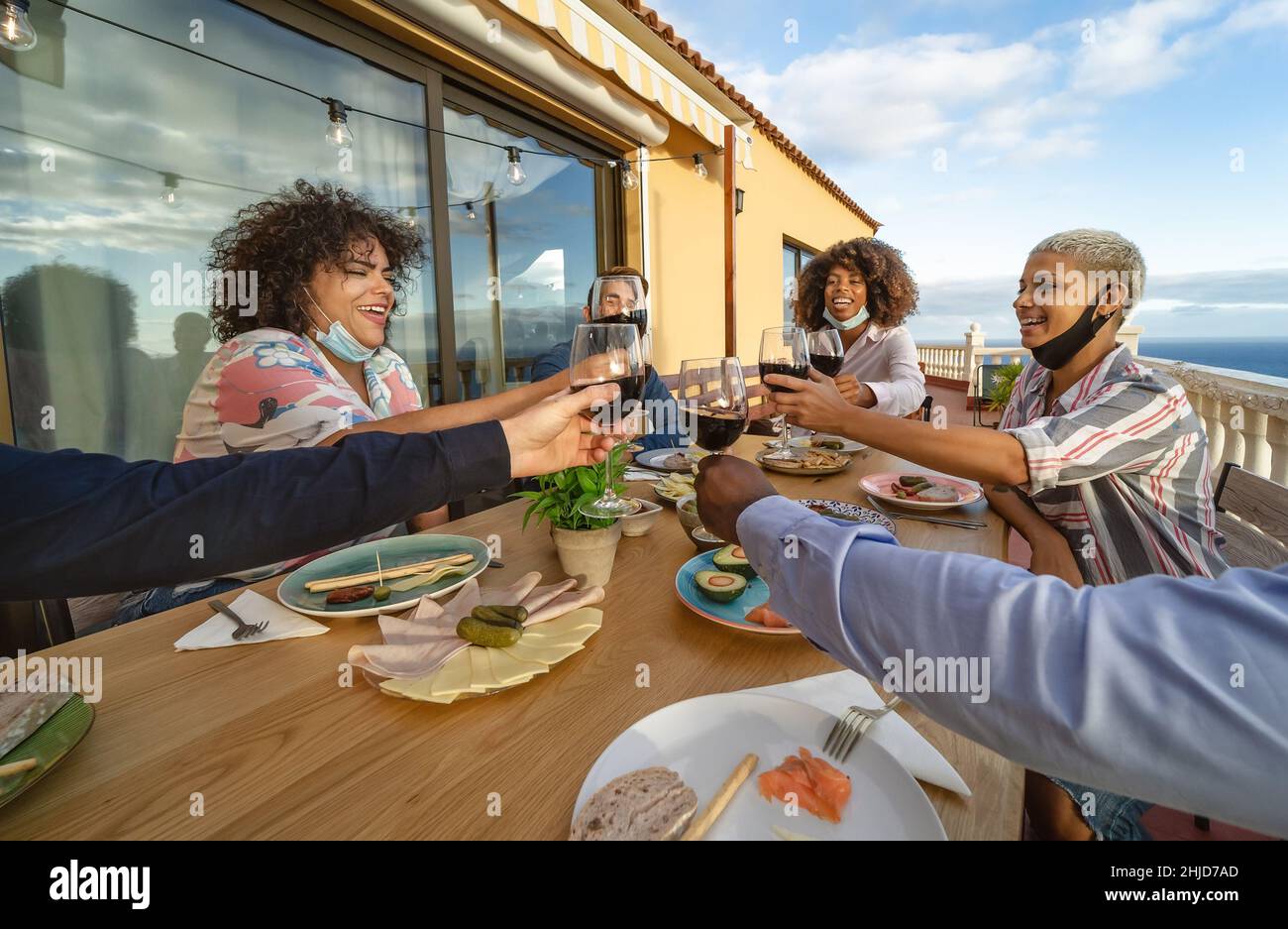 Les jeunes amis toaster avec des verres à vin rouge à l'apéritif du dîner - concept de boisson et de nourriture Banque D'Images