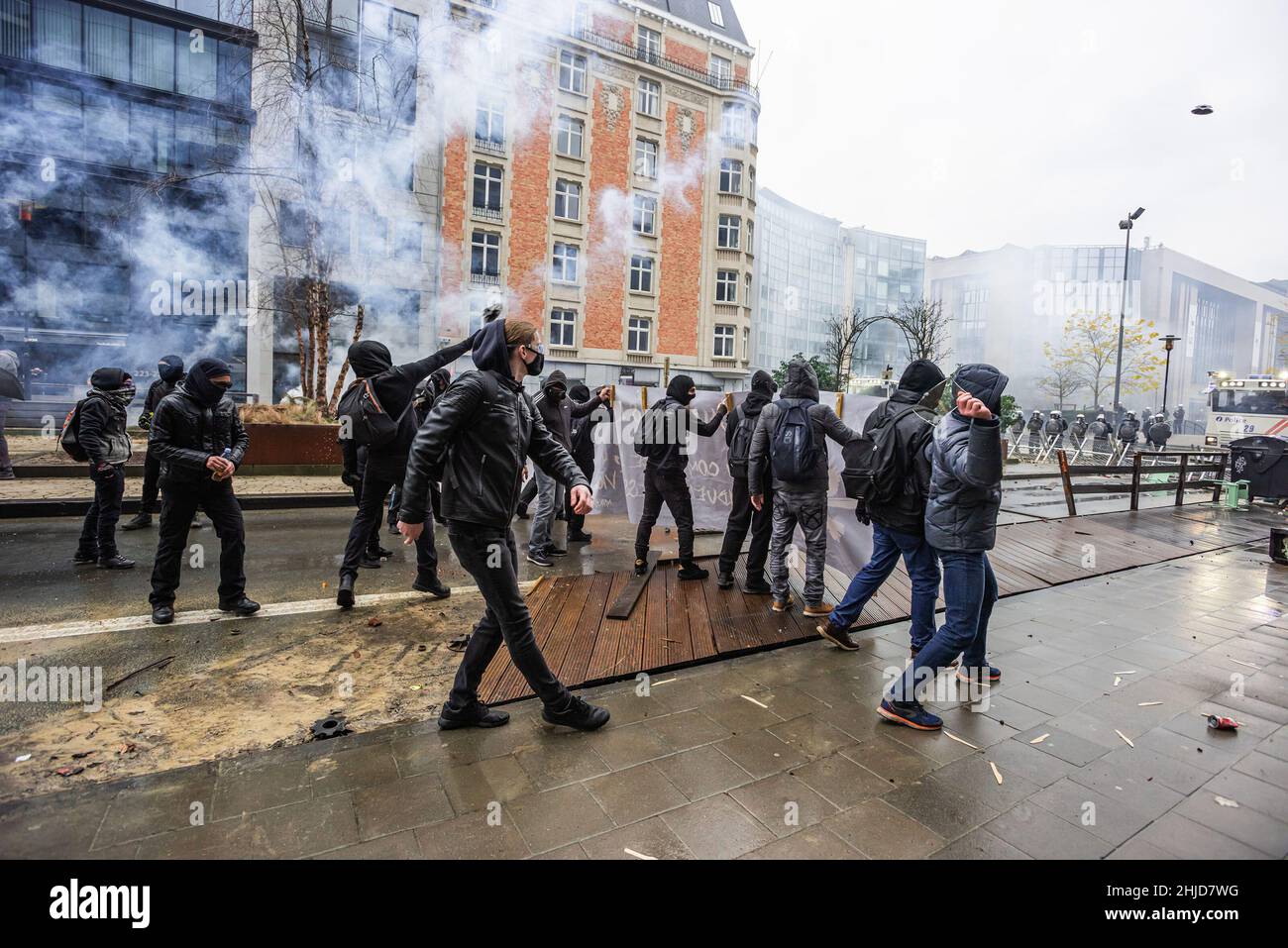 Les manifestants font face à la police avec du verre, des pierres et des parties de barricades improvisées au milieu de la fumée des gaz. La manifestation de fin de dimanche dans la ville belge de Bruxelles et au cœur de l'Union européenne a été entachée par une petite minorité qui n'a fait que se battre.Plus de 50 000 manifestants venus de toutes les parties de l'Europe ont participé à une manifestation contre le coronavirus anti-gouvernement, qui s'est passée sans incident.Une violente minorité vêtue de noir, renversait le district européen, ils ont vandalisé des voitures, des pierres ont été catapultés et lancées et des panneaux de signalisation routière déracinés, le devant de l'EEAS " Banque D'Images