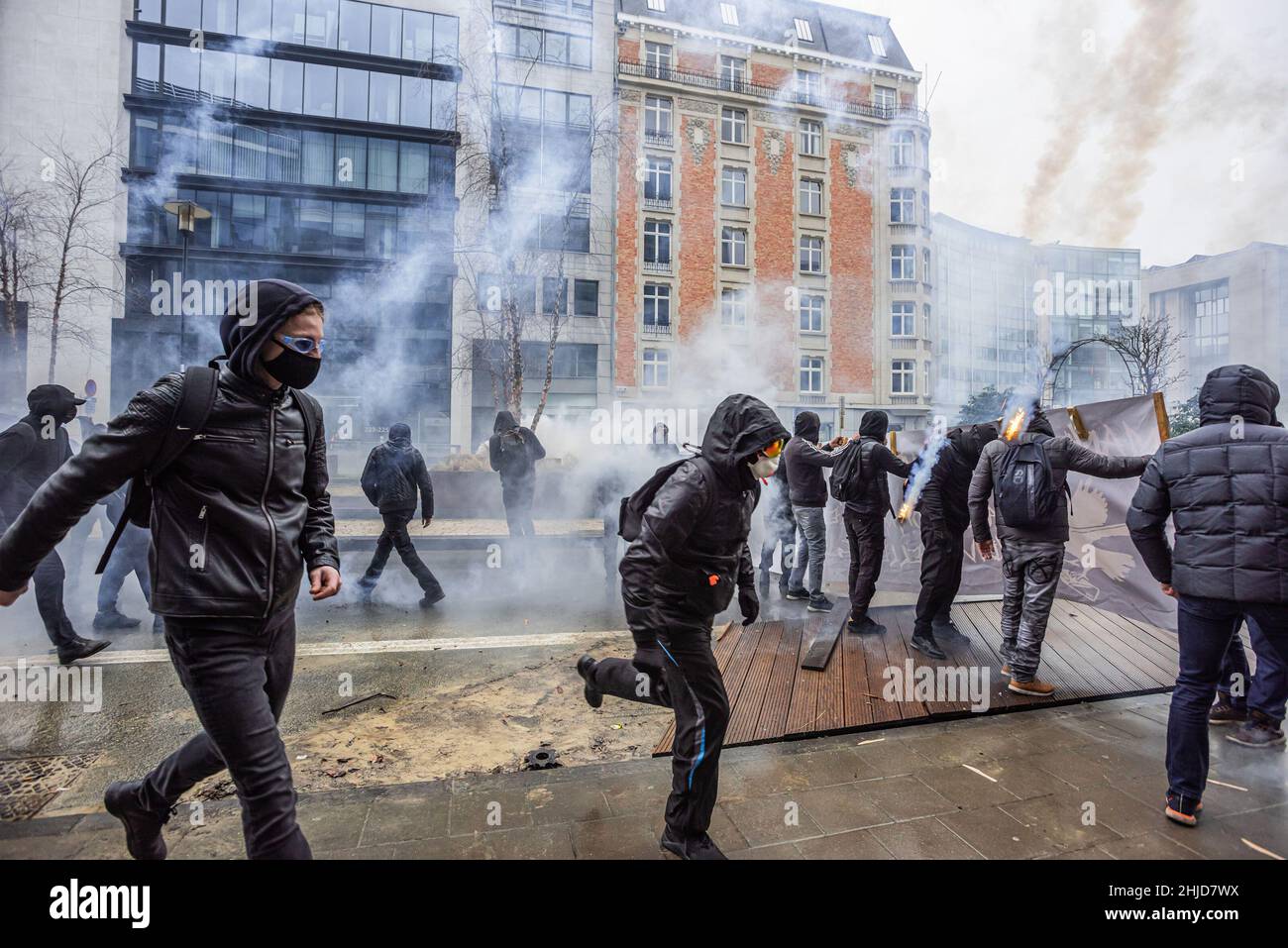 Les manifestants font face à la police avec du verre, des pierres et des parties de barricades improvisées au milieu de la fumée des gaz. La manifestation de fin de dimanche dans la ville belge de Bruxelles et au cœur de l'Union européenne a été entachée par une petite minorité qui n'a fait que se battre.Plus de 50 000 manifestants venus de toutes les parties de l'Europe ont participé à une manifestation contre le coronavirus anti-gouvernement, qui s'est passée sans incident.Une violente minorité vêtue de noir, renversait le district européen, ils ont vandalisé des voitures, des pierres ont été catapultés et lancées et des panneaux de signalisation routière déracinés, le devant de l'EEAS " Banque D'Images