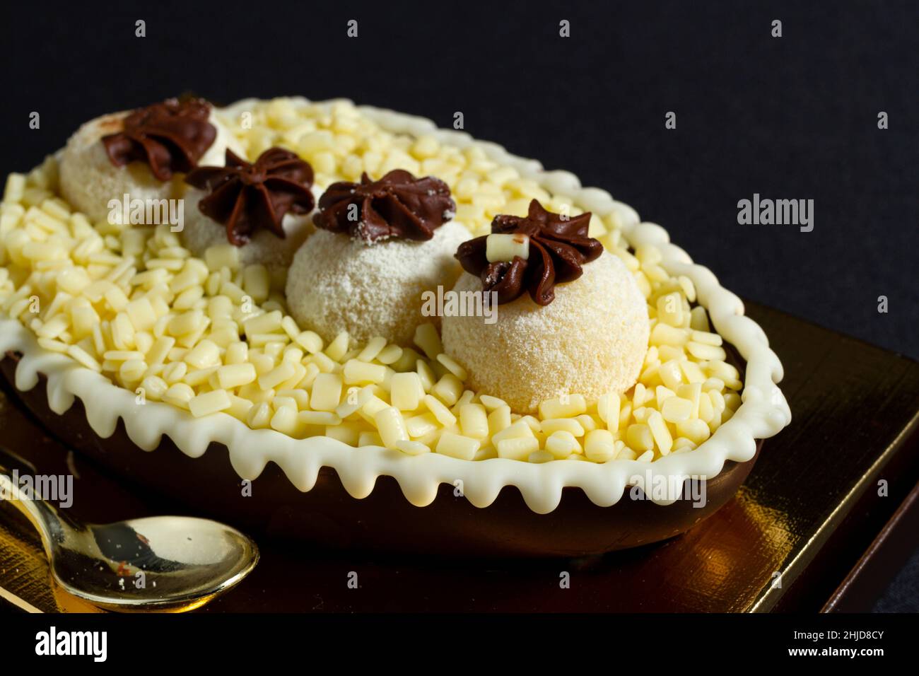 Œuf de pâques brésilien farci de chocolat blanc granulé et de crème, goûté avec une cuillère.Tradition de Pâques au Brésil Banque D'Images