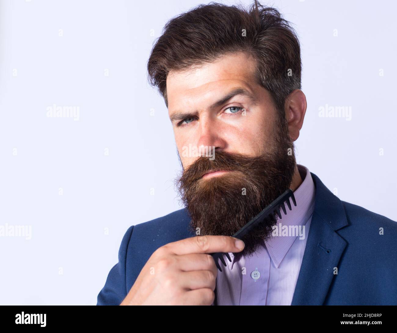 Jeune homme coiffant sa longue barbe avec un sabot.Homme barbu avec barbe,  gay barbu.Concept de barbershop.Hommes moustaches Photo Stock - Alamy