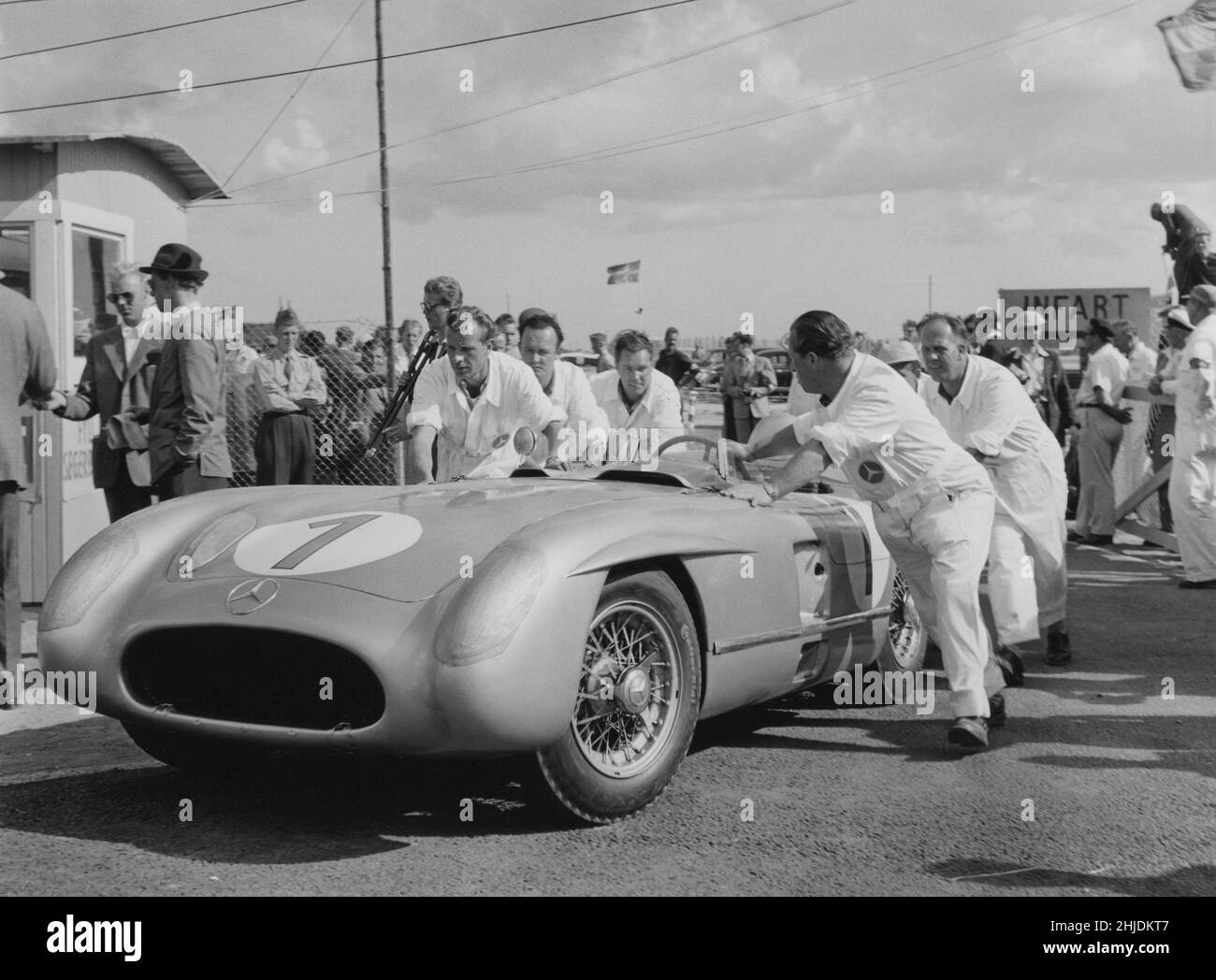Voiture de course du 1950s.L'équipe de mécaniciens Mercedes pousse une voiture de course Mercedes lors d'une course Grand prix 1955 dans la ville suédoise Kristianstad. Banque D'Images