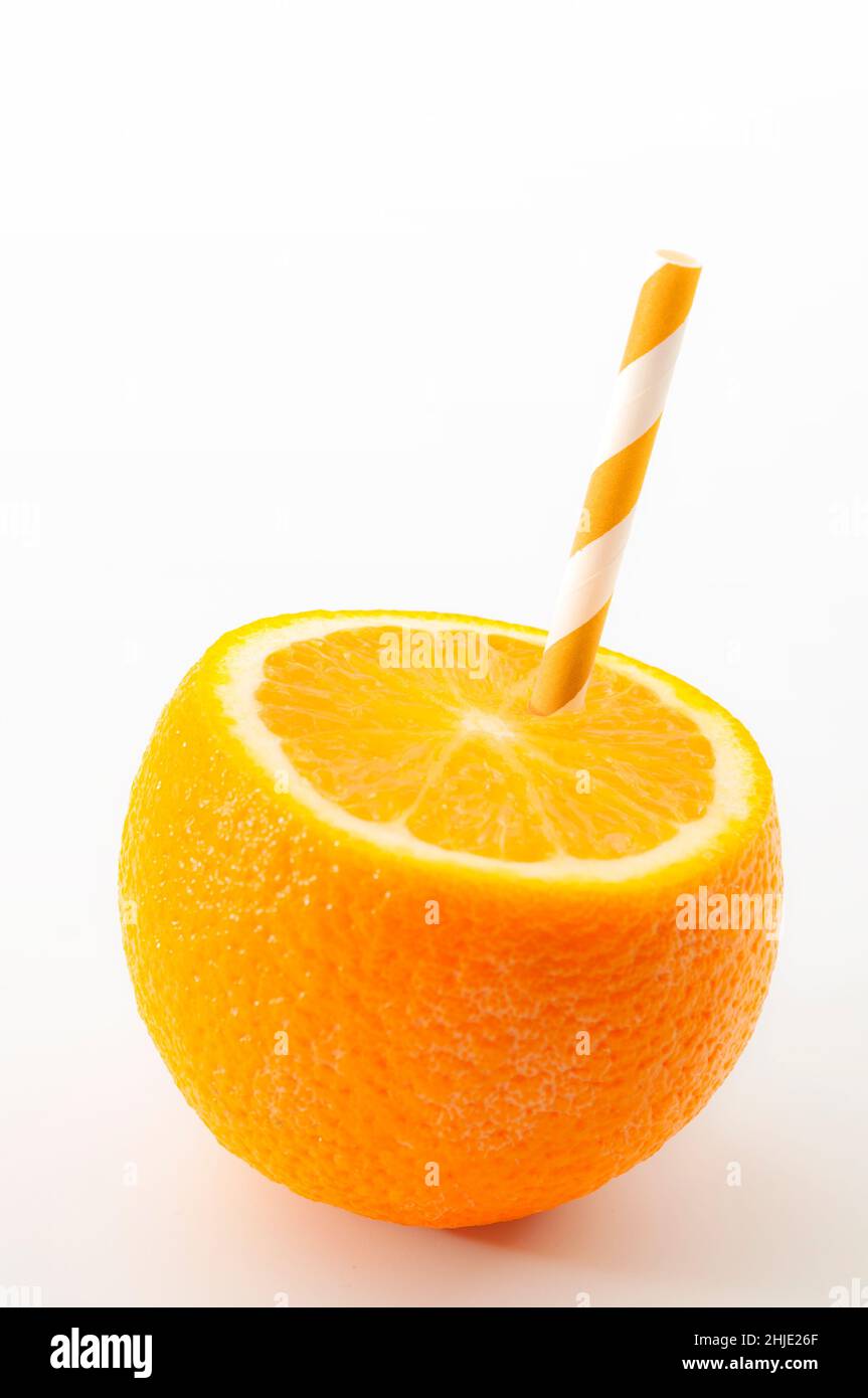 Routine matinale saine, source naturelle de vitamine c et de boisson de petit déjeuner thème avec une paille de boisson coincée dans une moitié d'orange isolé sur whi Banque D'Images