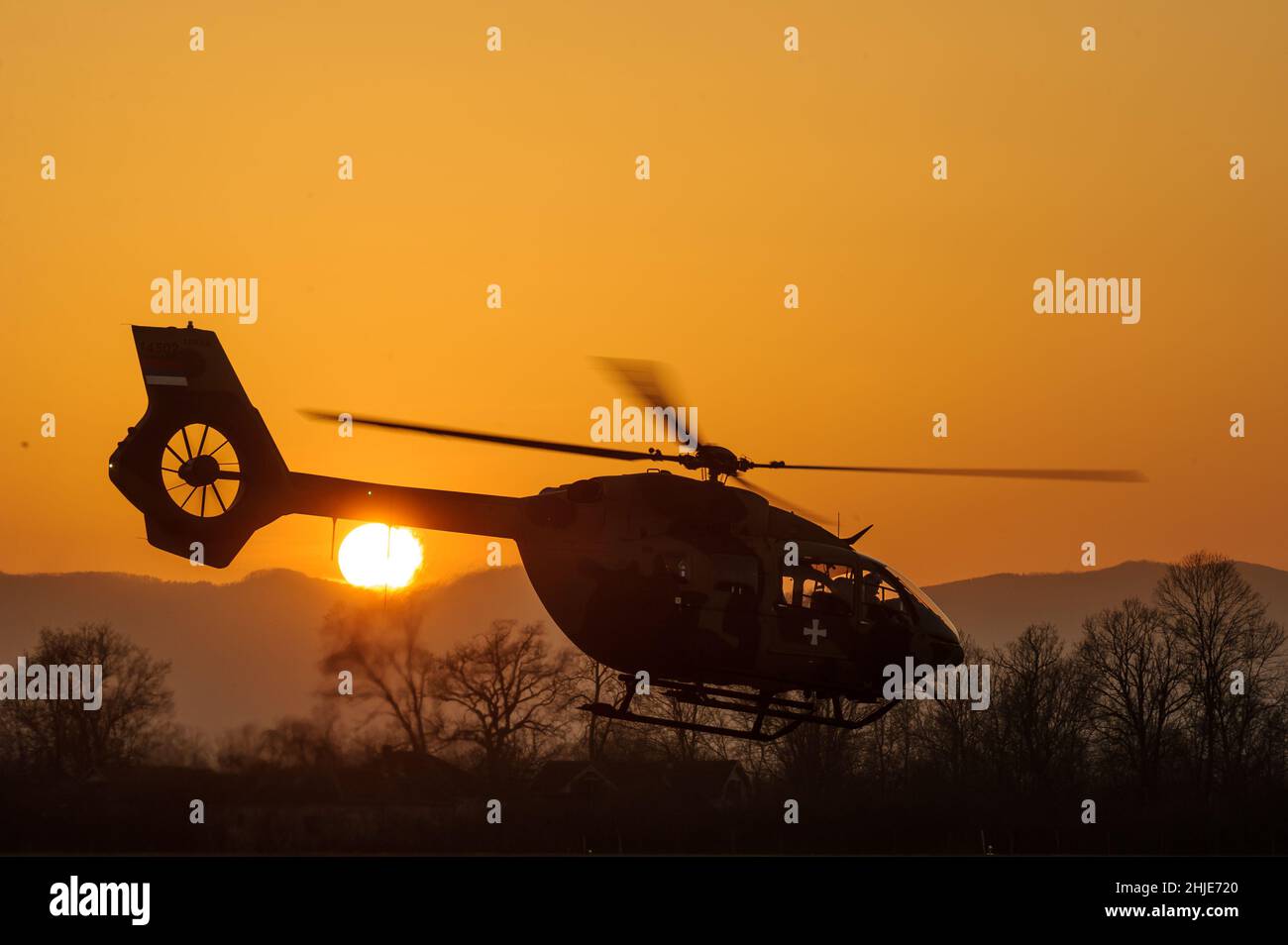 Décollage de l'hélicoptère bi-moteur H145M de la Force aérienne serbe Airbus, silhouette au coucher du soleil Banque D'Images