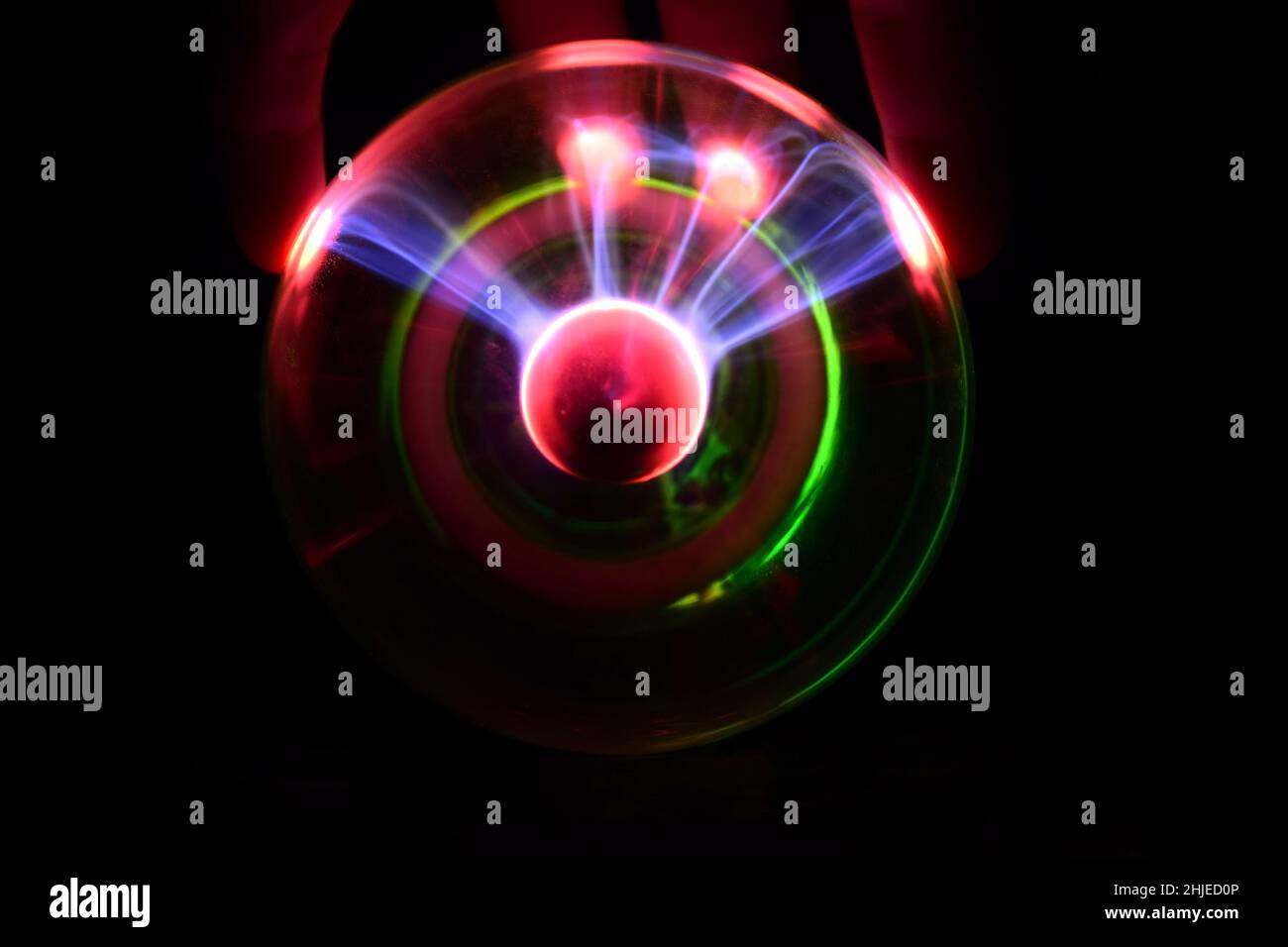 Boule de plasma avec des éclairs irisés dans différentes couleurs sur un fond très sombre Banque D'Images