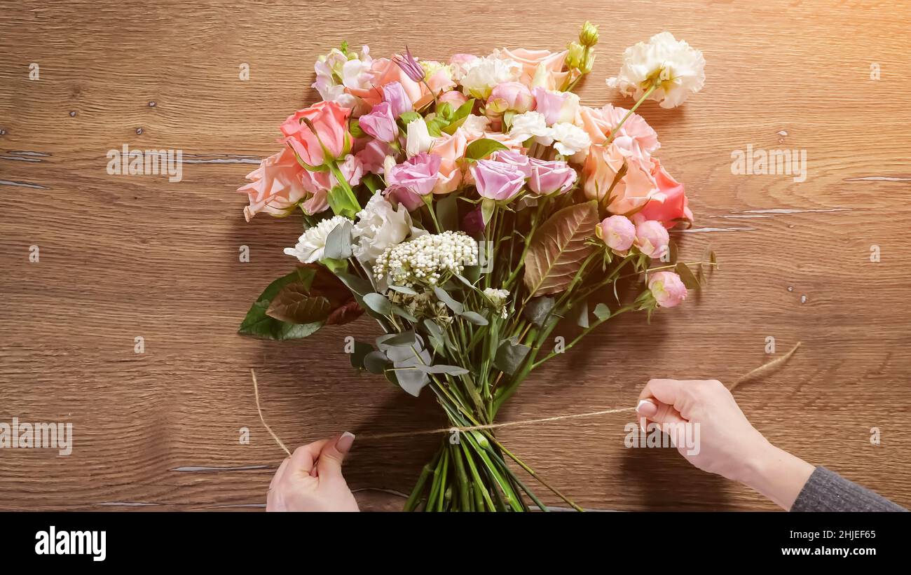 Bouquet de cravates fleuriste avec corde florale fine et flexible sur la table Banque D'Images