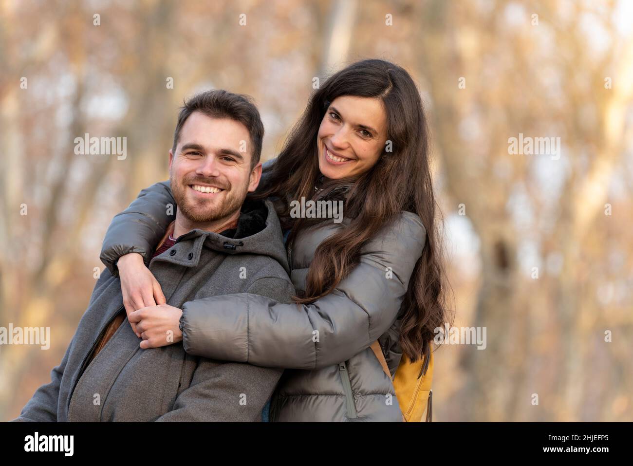 Un jeune couple adore s'embrasser dans le parc et regarder la caméra Banque D'Images