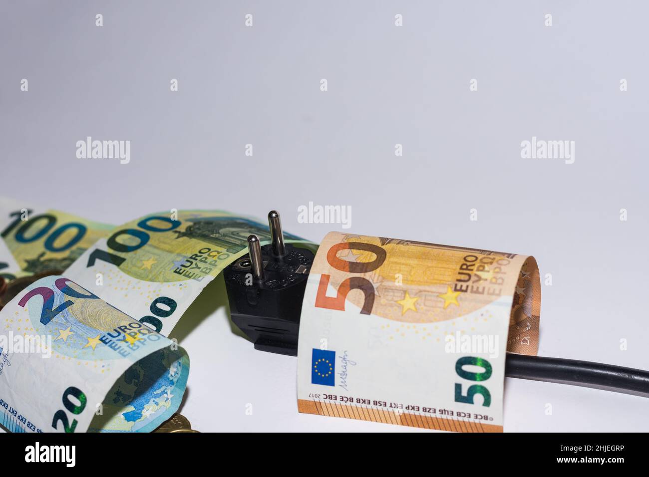 consommation d'énergie et augmentation des prix de l'électricité de nombreuses pièces et factures en euros avec une prise électrique sur fond gris vue détaillée Banque D'Images