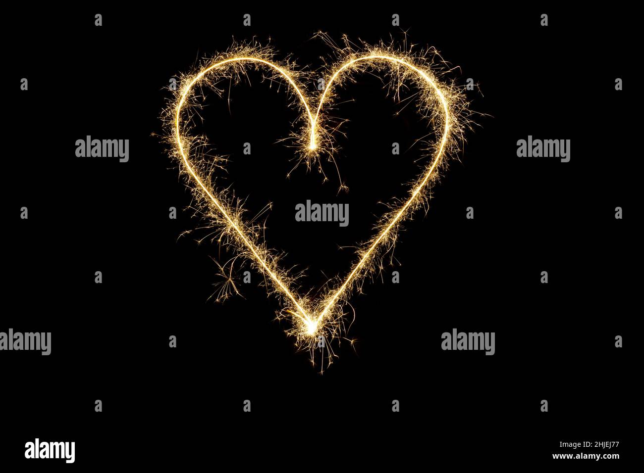 Forme de coeur en étincelles.Symbole d'amour de la Saint-Valentin, coeur lumineux sur fond noir Banque D'Images