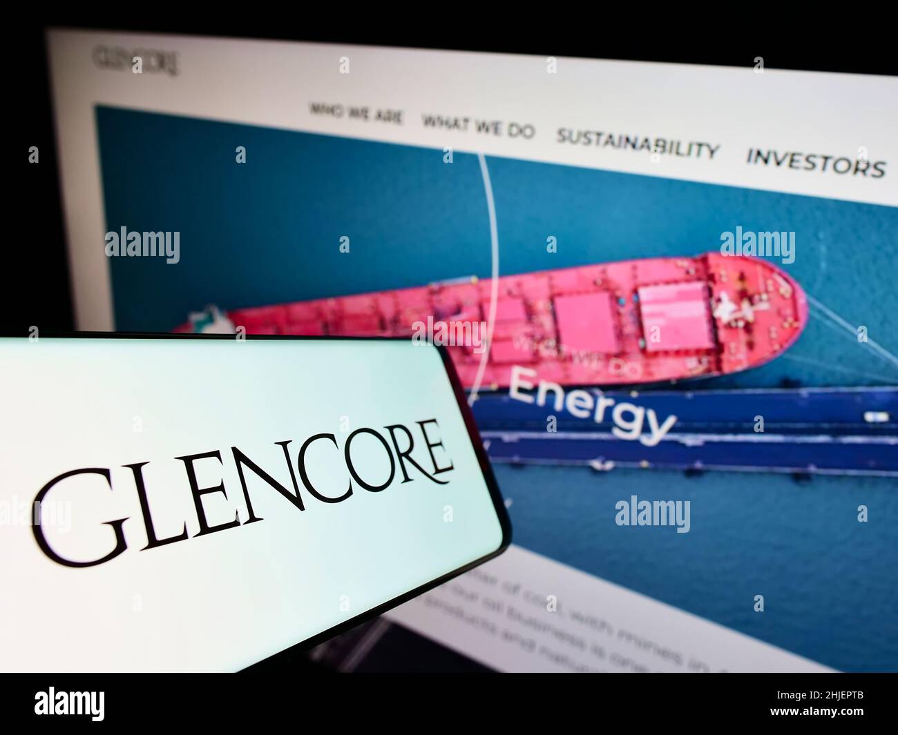 Smartphone avec le logo de la société de commerce de marchandises Glencore plc à l'écran devant le site Web d'affaires.Mise au point au centre-gauche de l'écran du téléphone. Banque D'Images