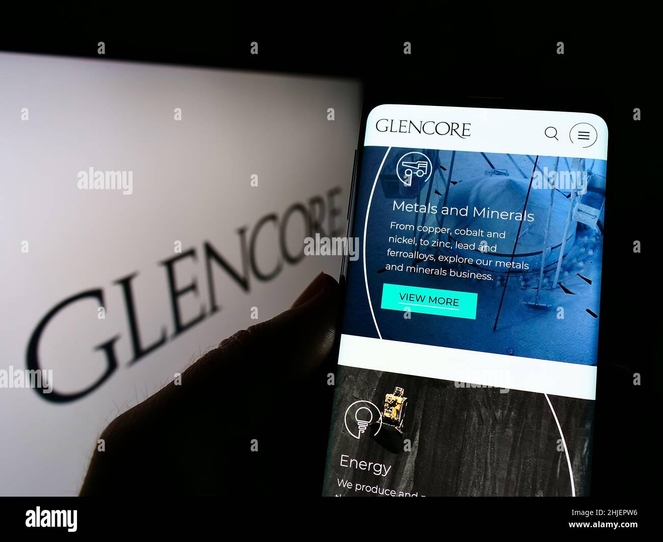Personne tenant un téléphone portable avec le site Web de la société de commerce de marchandises Glencore plc à l'écran devant le logo.Concentrez-vous sur le centre de l'écran du téléphone. Banque D'Images