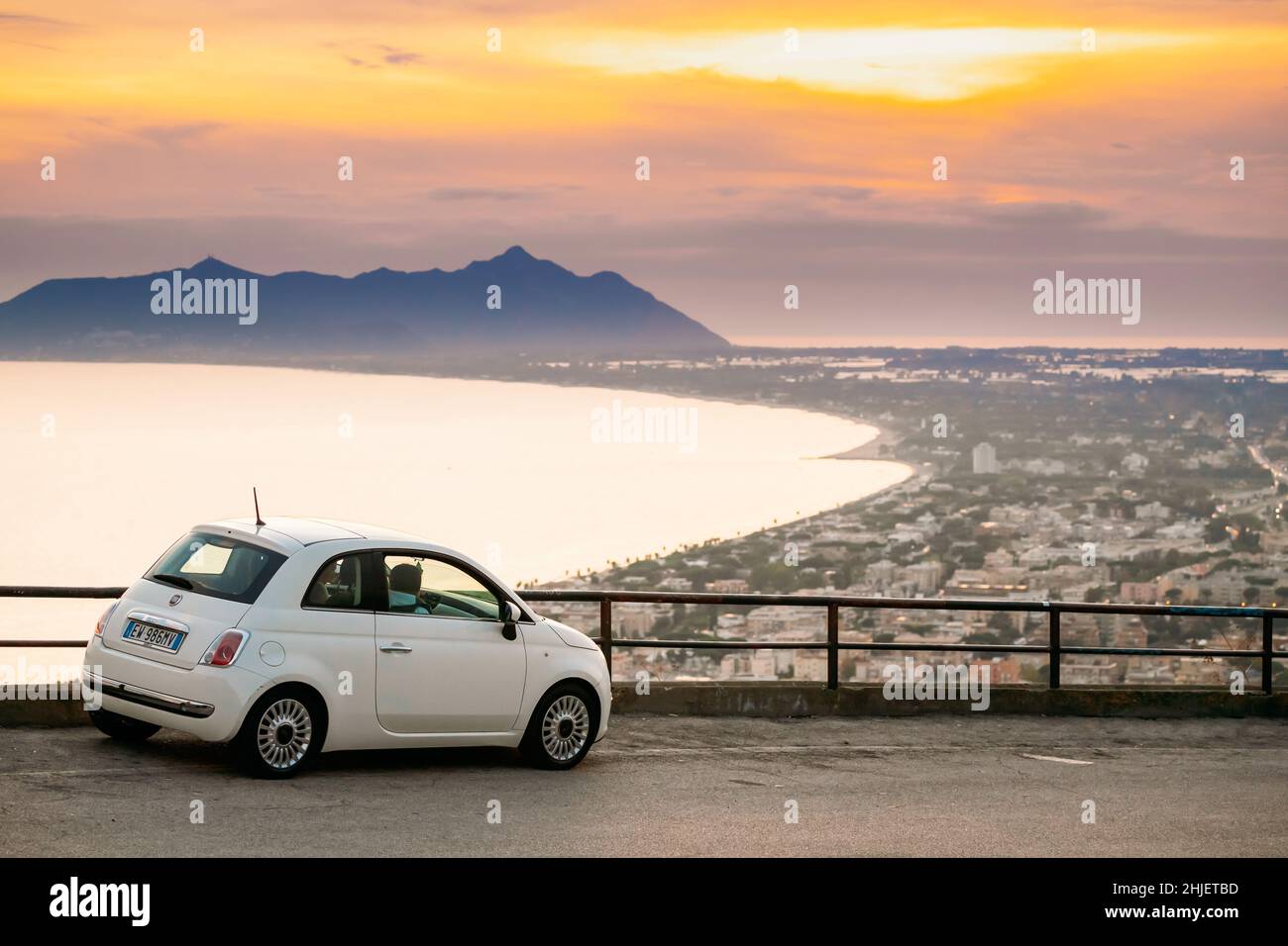 Terracina, Italie.Couleur blanche Fiat 500 Facelift 2016 voiture garée sur fond Circeo Promontory et la mer Tyrrhénienne au coucher du soleil ou au lever du soleil Banque D'Images