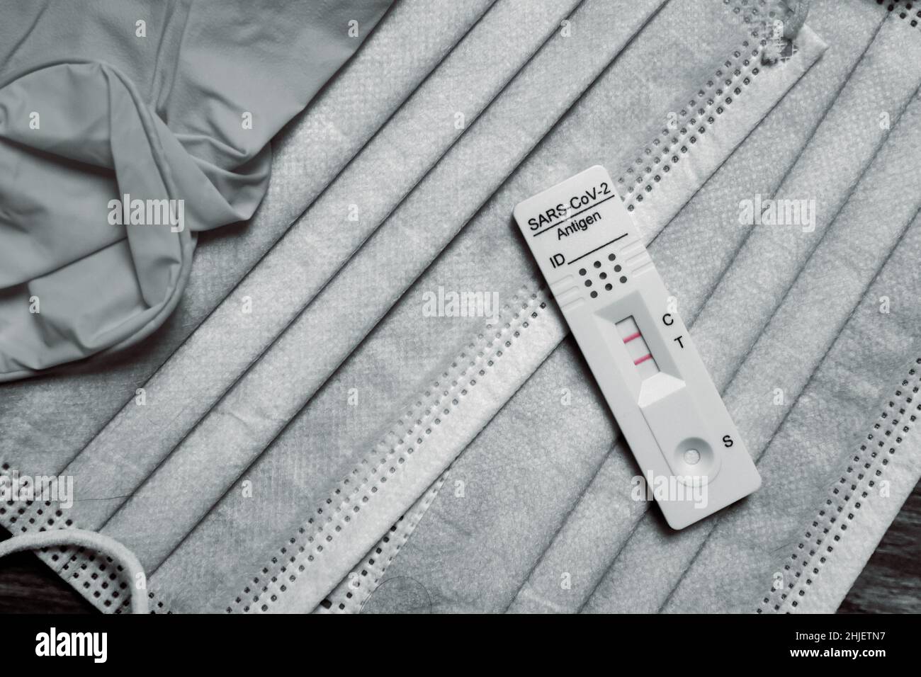 Vue de dessus des masques médicaux et de l'auto-test rapide de l'antigène montrant un résultat positif pour le coronavirus (Covid-19) Banque D'Images