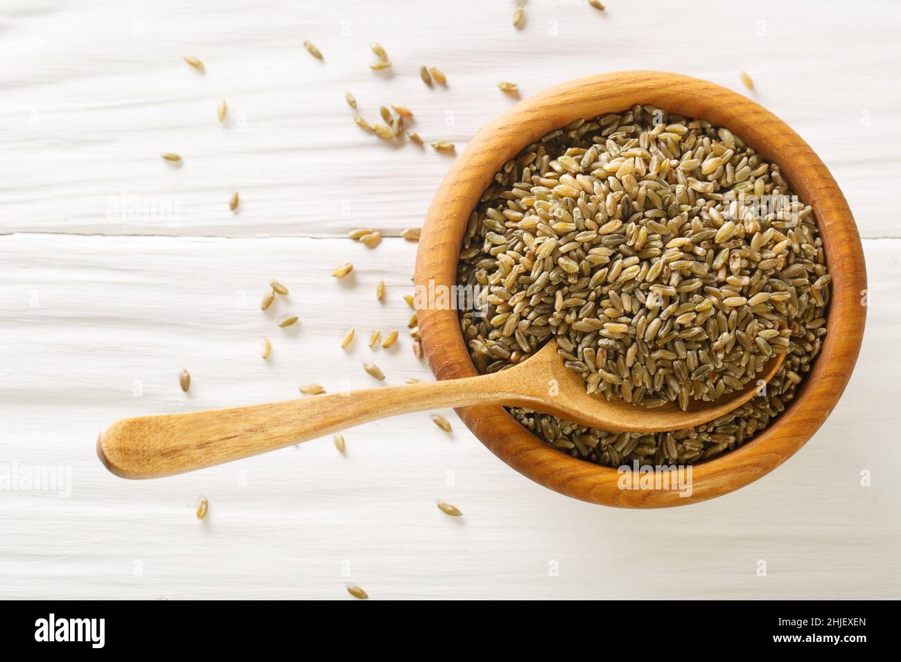 Freekah de blé cru biologique dans un bol avec une cuillère en bois sur table rustique blanche.Vue horizontale du dessus Banque D'Images