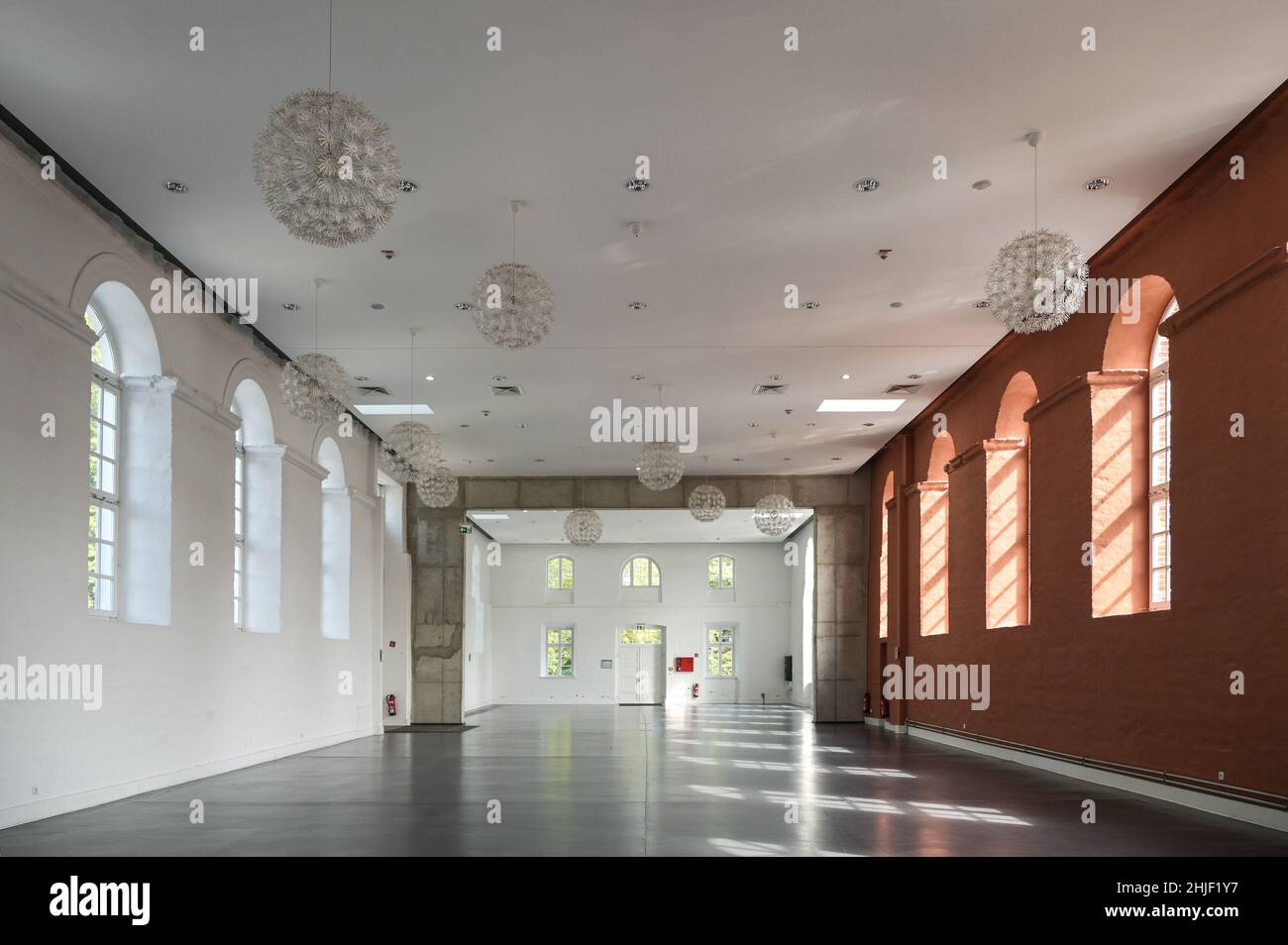 Putbus, Allemagne, 22 août 2021: Grande salle vide avec murs blancs et rouges et fenêtres voûtées, espace d'événement à l'intérieur dans le Marstall de Putbus sur l'is Banque D'Images