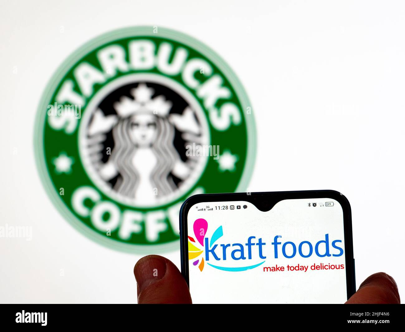 Dans cette illustration, le logo Kraft Foods Group, Inc. Est affiché sur un écran de smartphone avec le logo Starbucks Corporation en arrière-plan. Banque D'Images
