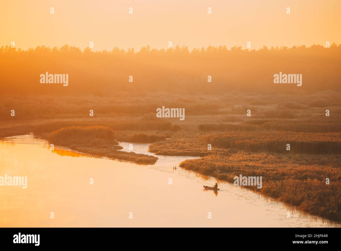 Lac calme, rivière et bateau de pêche en fauchage unique pendant le beau lever du soleil en automne matin.Paysage paisible d'automne Banque D'Images