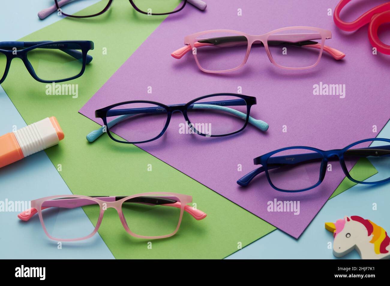 Photo de lunettes de différentes couleurs de cadres avec des papiers de  couleur un ciseau rose et une licorne Photo Stock - Alamy