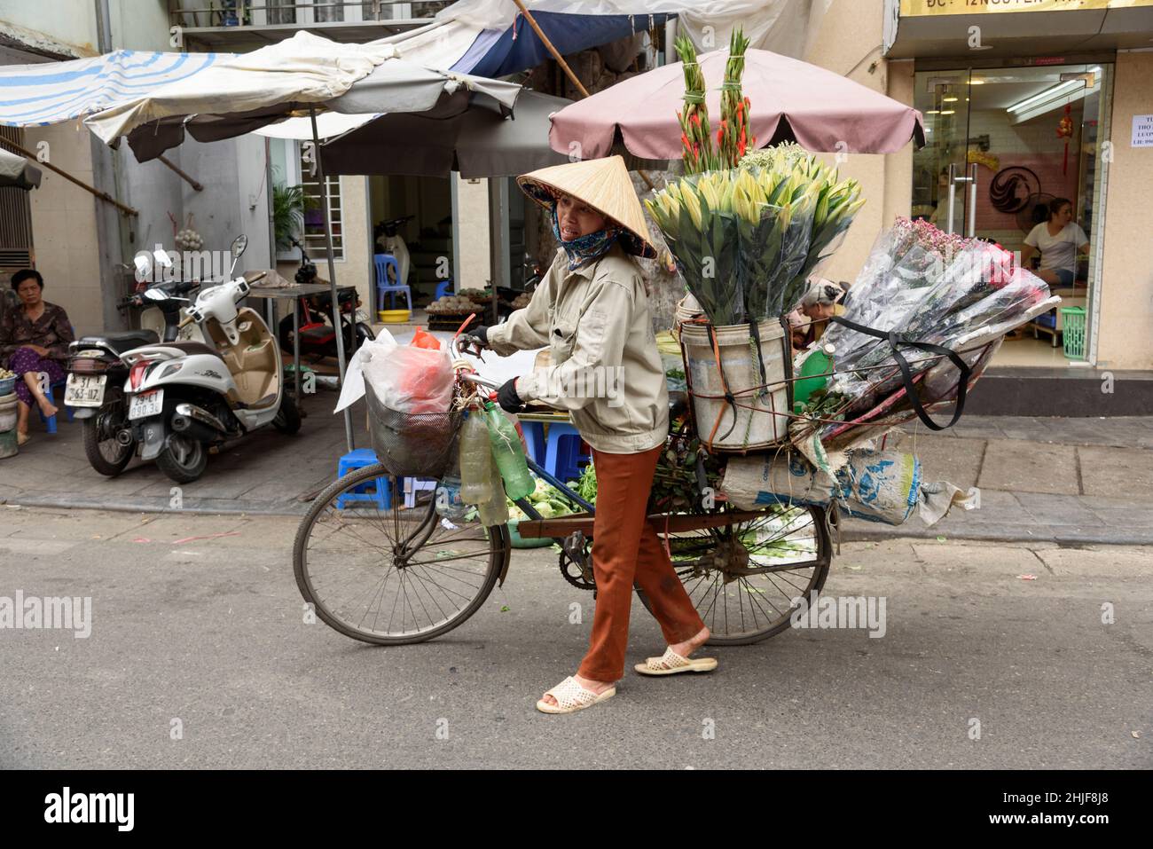 Un vendeur de fleurs traditionnel avec son vélo dans les rues du vieux quartier de Hanoi, Vietnam, Asie du Sud-est Banque D'Images